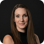 Nicole Prior, team member at Prosperia Marketing, portrait with long hair and a black background.