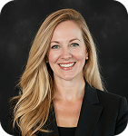 Reagan Johnson, Marketing Strategist at Prosperia Marketing, smiling in professional attire against a dark background, representing the agency's focus on strategic marketing solutions and client engagement.